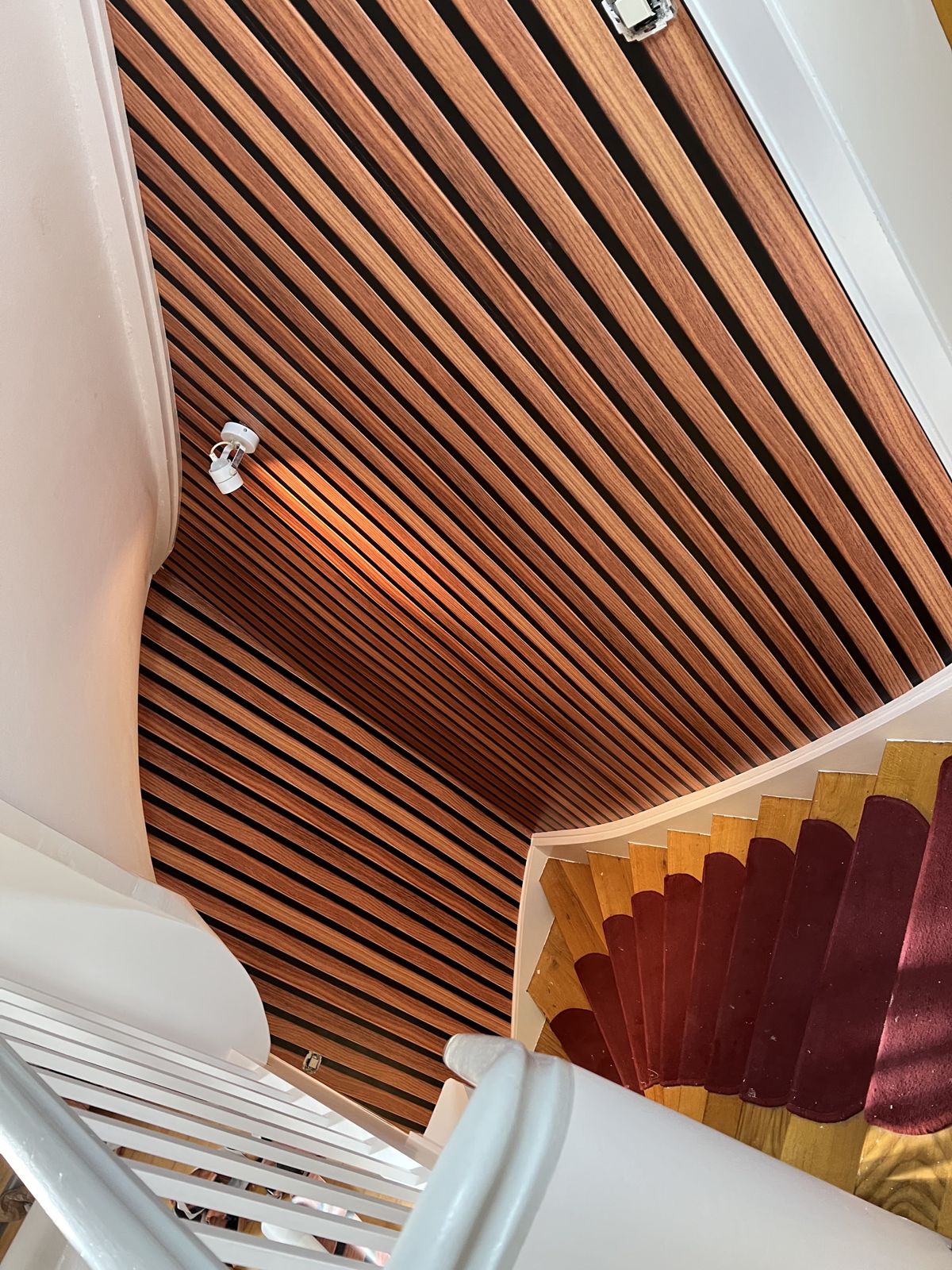 Treppenhaus mit Holzlamellen an Wand und Decke